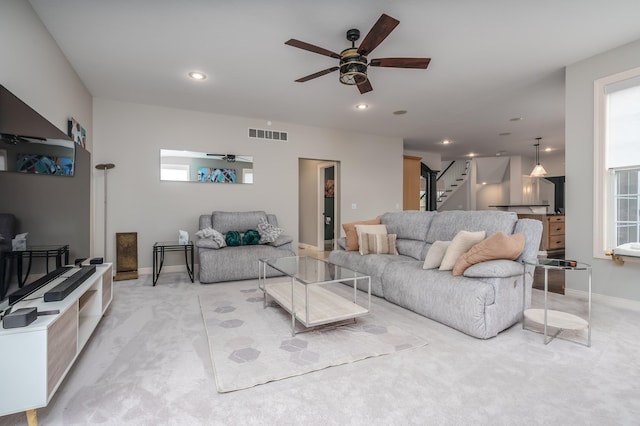 carpeted living room featuring ceiling fan