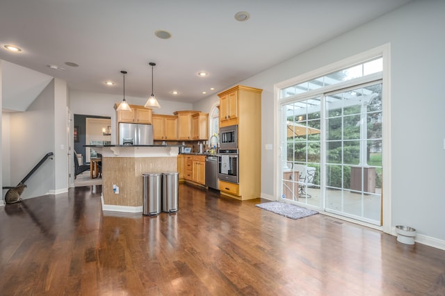 kitchen with a kitchen island, hanging light fixtures, stainless steel appliances, a breakfast bar, and dark hardwood / wood-style flooring