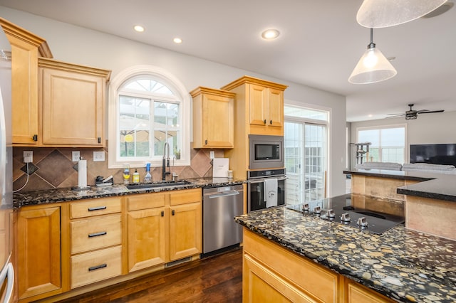 kitchen featuring sink, appliances with stainless steel finishes, decorative light fixtures, and plenty of natural light