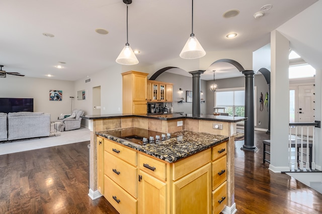 kitchen with black cooktop, a center island, ornate columns, pendant lighting, and dark hardwood / wood-style floors