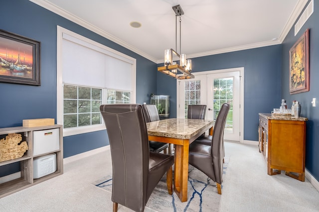 carpeted dining area with a notable chandelier, ornamental molding, and french doors