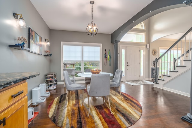 dining area with ornate columns, a healthy amount of sunlight, and dark hardwood / wood-style flooring