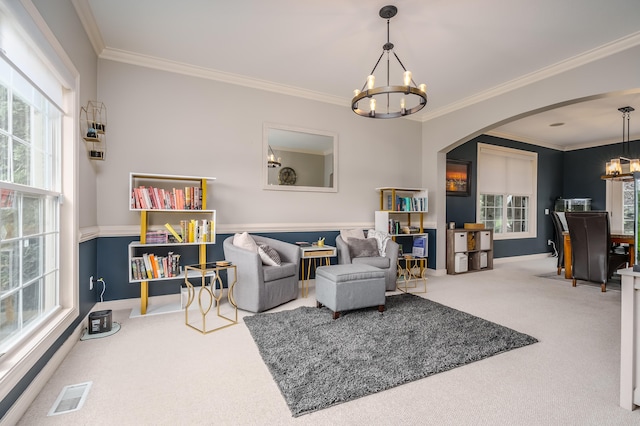 sitting room with crown molding, carpet, and an inviting chandelier