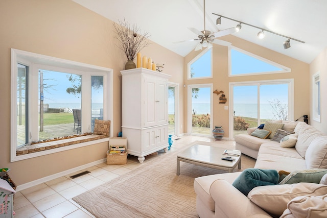 living room featuring a water view, light tile patterned flooring, and plenty of natural light