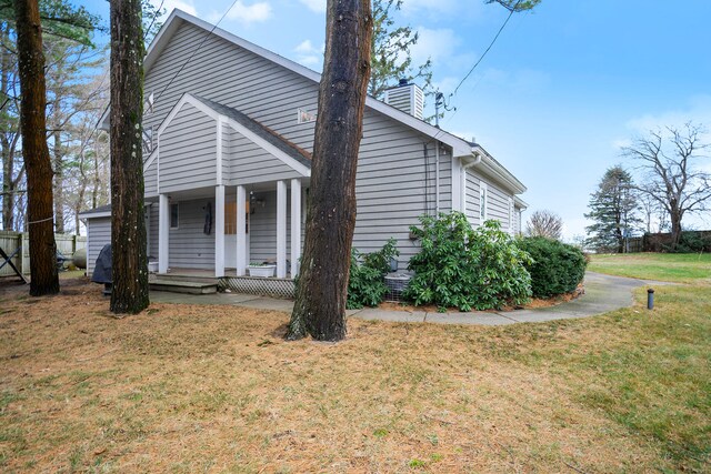 view of side of home featuring a porch and a yard