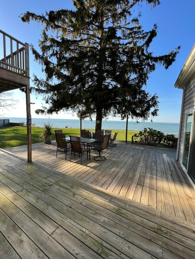 wooden deck with a yard and a water view