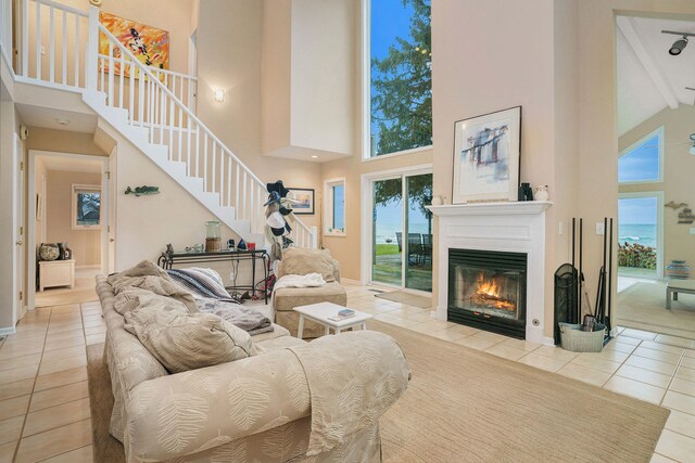 tiled living room with beam ceiling and high vaulted ceiling