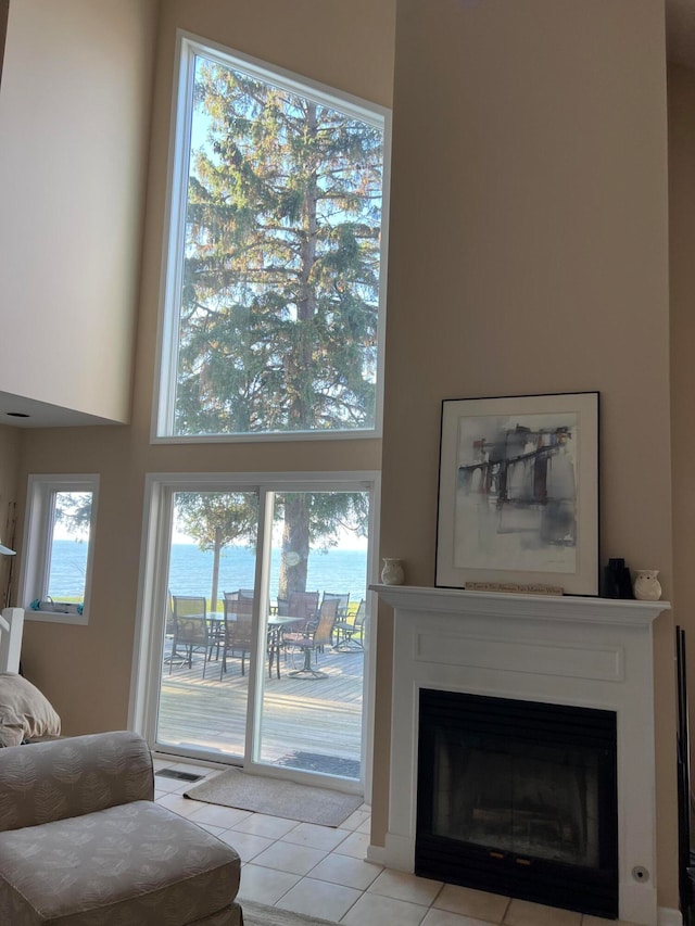 tiled living room with a towering ceiling and a healthy amount of sunlight