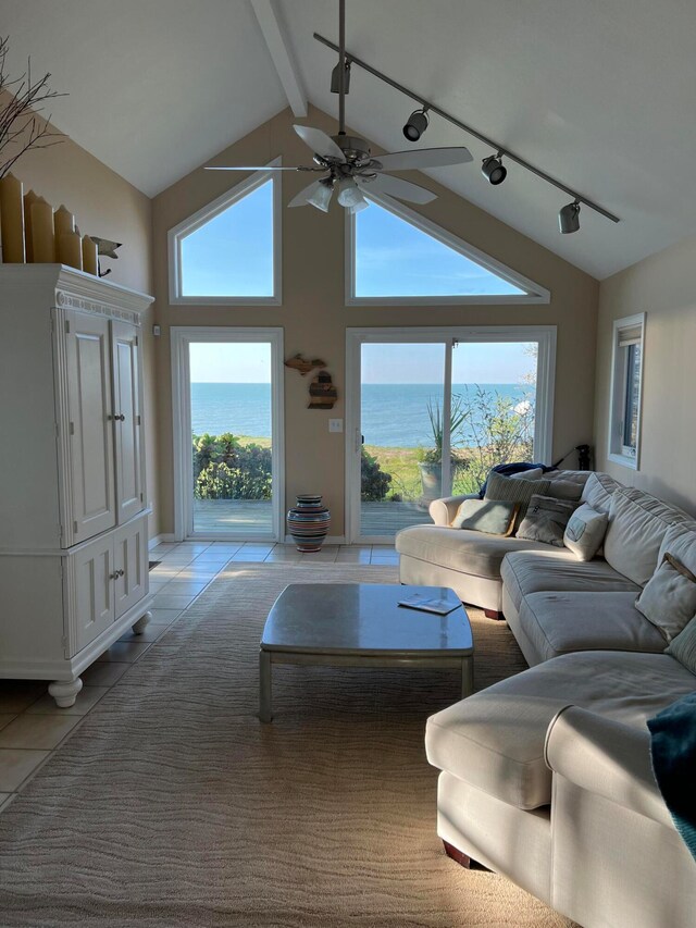 tiled living room with vaulted ceiling, track lighting, a water view, and ceiling fan