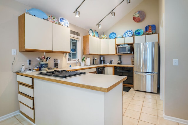 kitchen featuring lofted ceiling, kitchen peninsula, stainless steel appliances, sink, and white cabinets