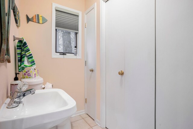 bathroom with toilet, tile patterned floors, and sink