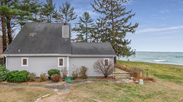 view of home's exterior with a yard and a water view