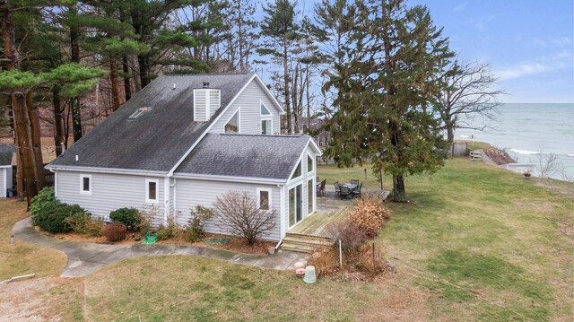 view of property exterior featuring a water view and a yard