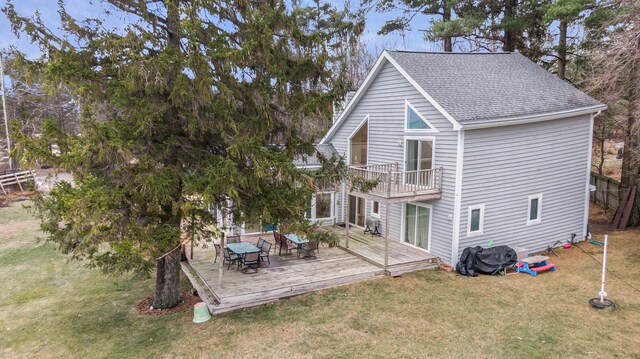 rear view of property featuring a wooden deck and a yard