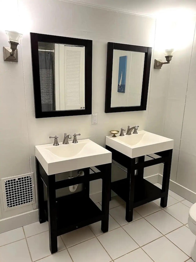 bathroom with vanity, toilet, and tile patterned floors