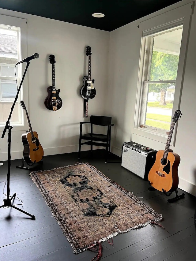 misc room with a wall mounted AC and dark hardwood / wood-style flooring