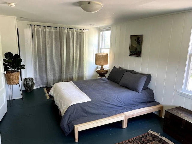 bedroom featuring multiple windows and dark hardwood / wood-style flooring