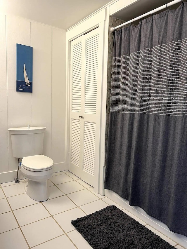 bathroom featuring tile patterned floors, curtained shower, and toilet