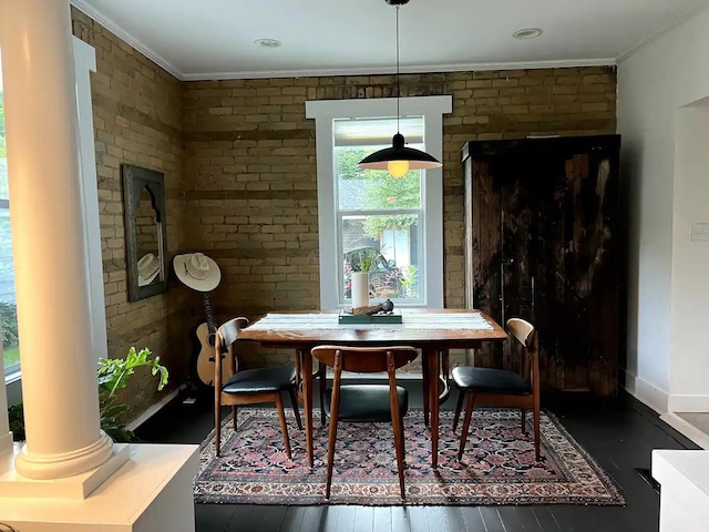 dining space with ornate columns, ornamental molding, and dark hardwood / wood-style flooring