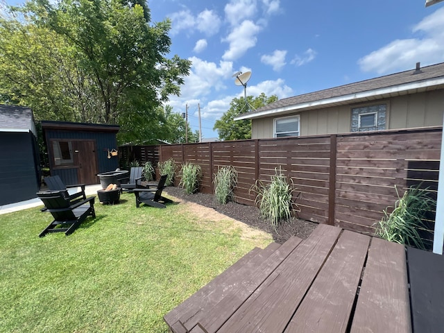 view of yard featuring a storage shed and a fire pit