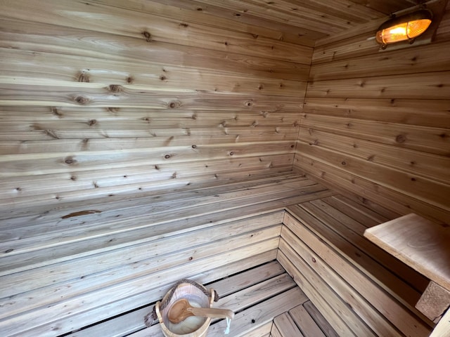 view of sauna with wooden ceiling and wooden walls