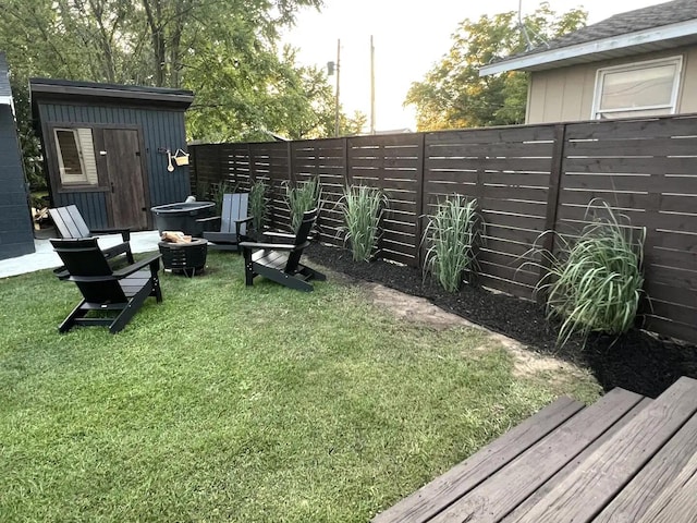 view of yard with a shed and a fire pit