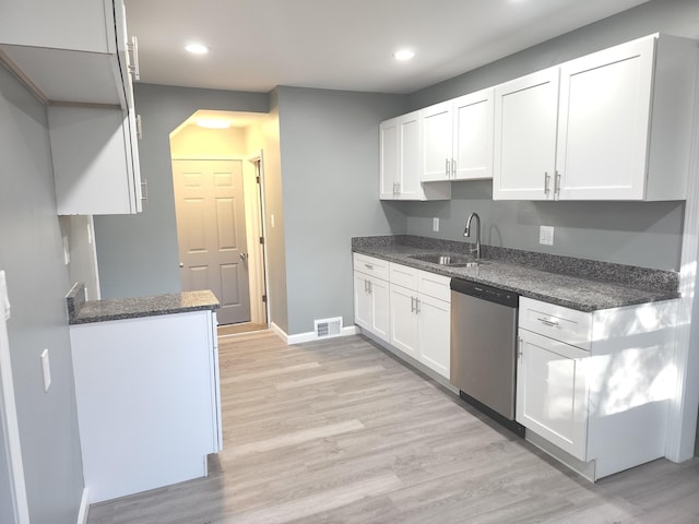 kitchen with stainless steel dishwasher, sink, white cabinetry, and light hardwood / wood-style flooring