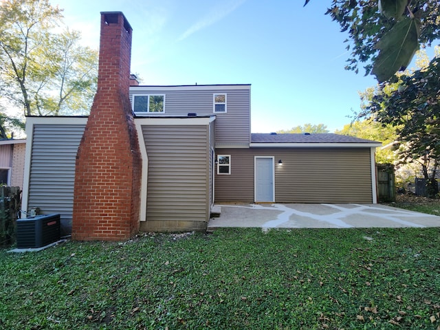 rear view of property featuring a yard, a patio area, and central AC