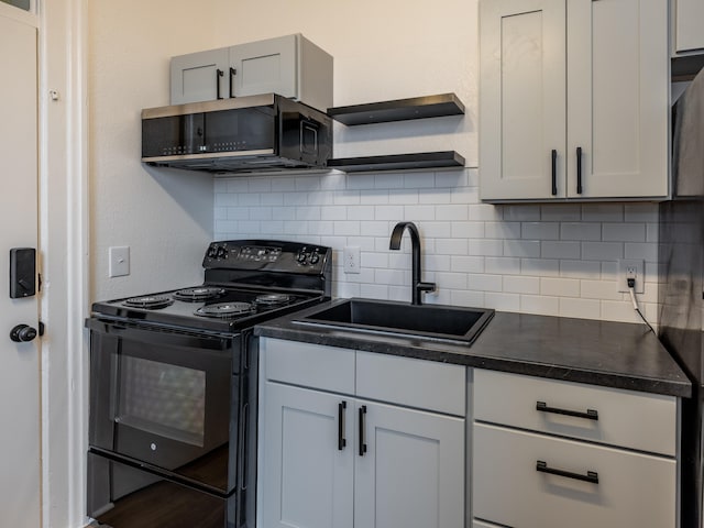 kitchen featuring tasteful backsplash, black electric range, and sink