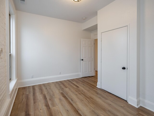 unfurnished bedroom featuring a closet and light hardwood / wood-style flooring