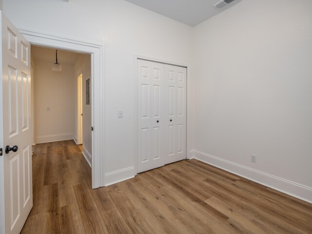 unfurnished bedroom with hardwood / wood-style flooring and a closet