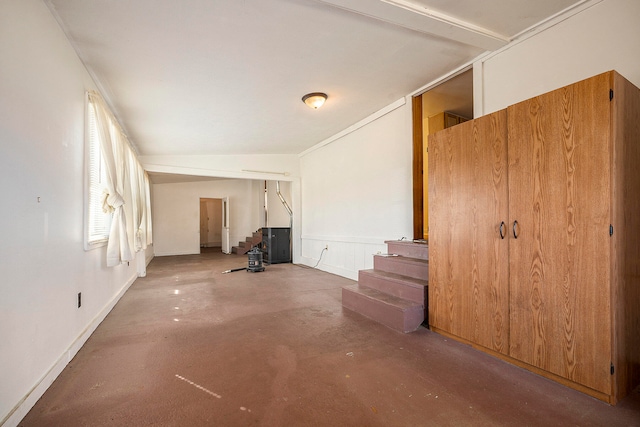 unfurnished living room with vaulted ceiling and concrete floors