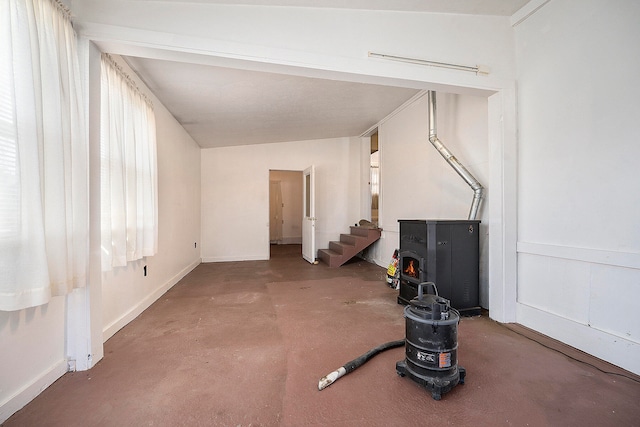 living room with a wood stove and concrete flooring