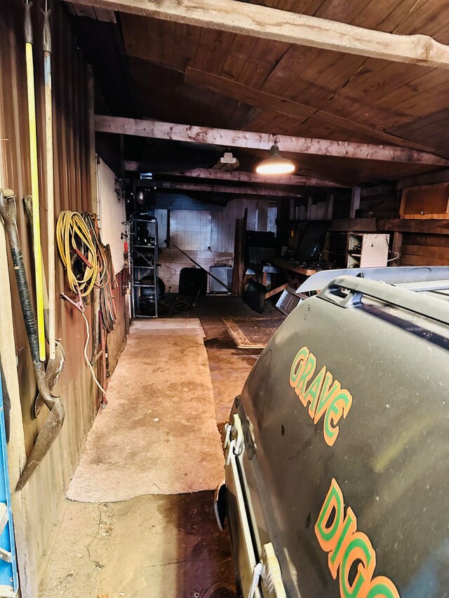 garage featuring wood ceiling and wood walls