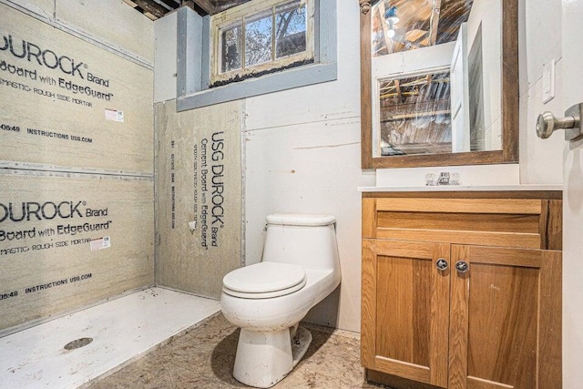 bathroom featuring toilet, vanity, and a shower