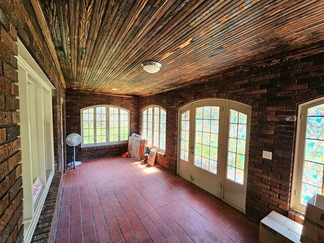 unfurnished sunroom with wood ceiling and plenty of natural light