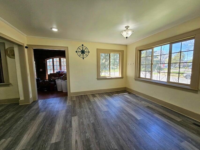 unfurnished dining area with dark wood-type flooring, a healthy amount of sunlight, and ornamental molding