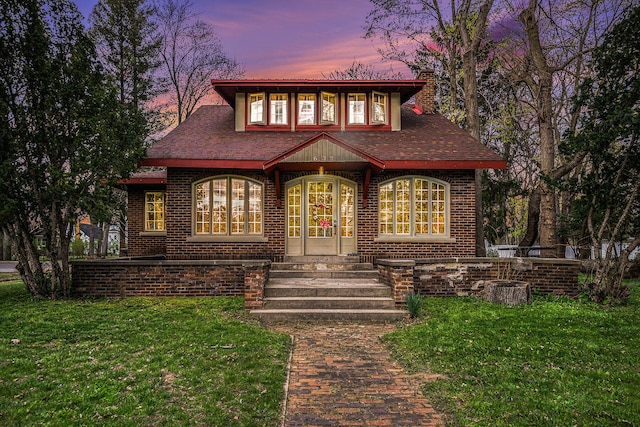 view of front facade with a yard and french doors