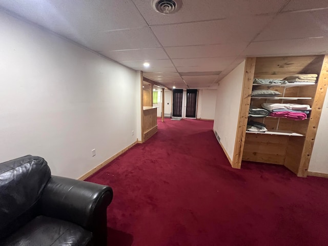 hallway featuring carpet flooring and a drop ceiling