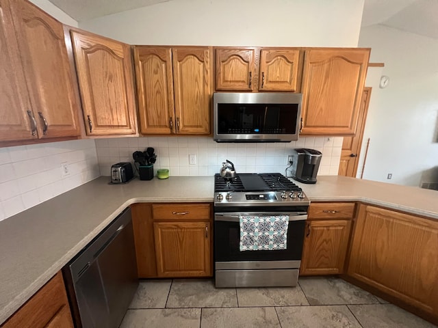 kitchen featuring tasteful backsplash, appliances with stainless steel finishes, and vaulted ceiling