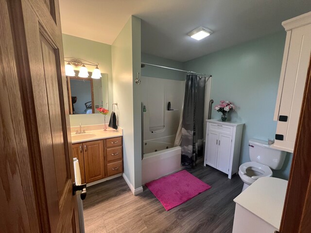 full bathroom featuring hardwood / wood-style floors, vanity, shower / bathtub combination with curtain, and toilet