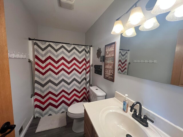 bathroom featuring walk in shower, hardwood / wood-style floors, vanity, and toilet