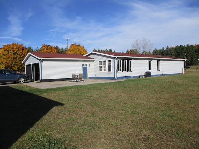 back of property featuring central AC, a yard, a garage, and a patio area