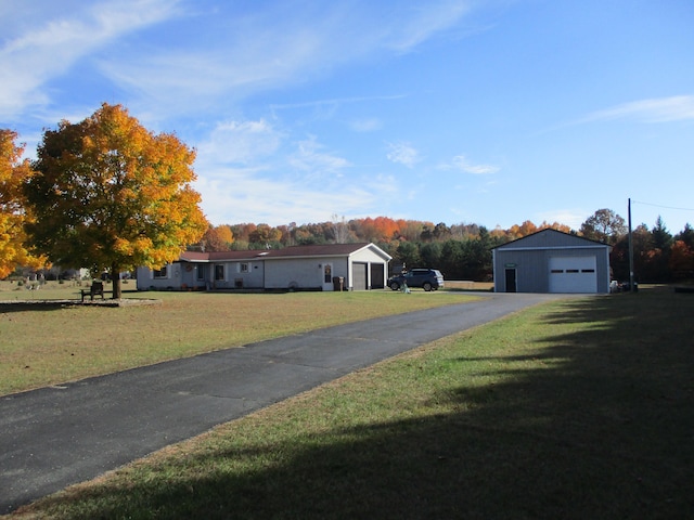 view of front of home featuring an outdoor structure, a front yard, and a garage