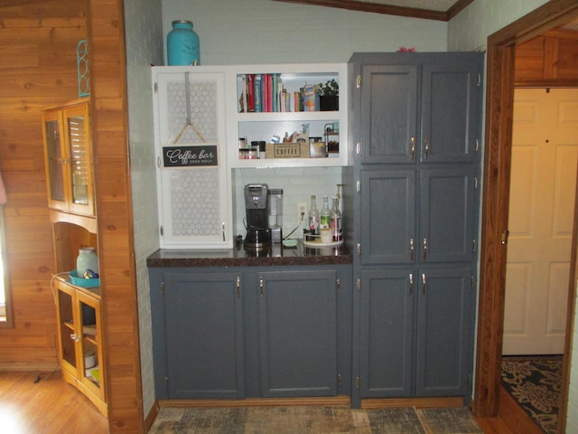 bar featuring hardwood / wood-style flooring, gray cabinets, and vaulted ceiling