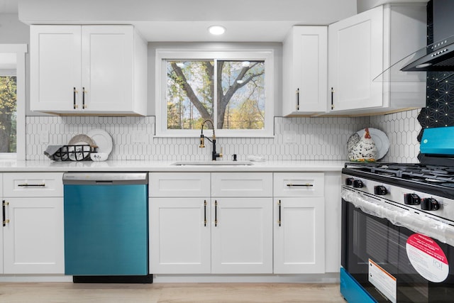 kitchen featuring appliances with stainless steel finishes, wall chimney exhaust hood, white cabinetry, and backsplash