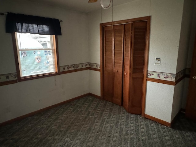 unfurnished bedroom with a closet, ceiling fan, and dark carpet