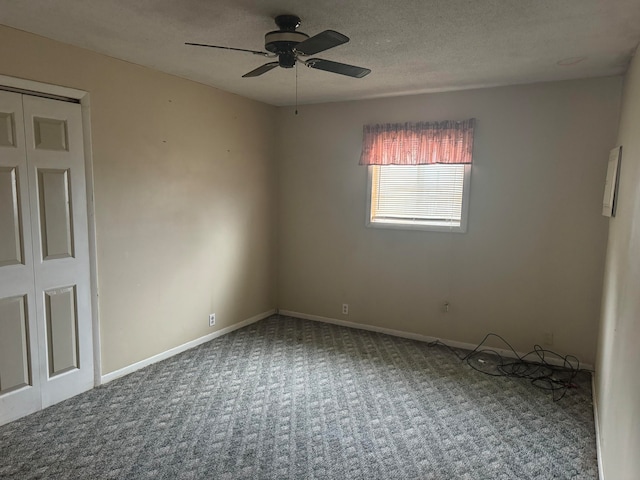 unfurnished room featuring a textured ceiling, ceiling fan, and carpet floors