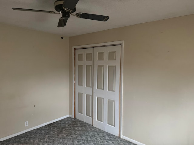 unfurnished bedroom with a closet, ceiling fan, and dark colored carpet