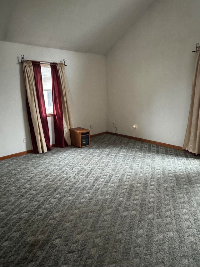 empty room with carpet flooring and vaulted ceiling